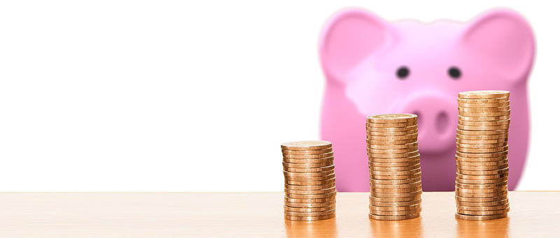 Piggy bank and rows of neatly stacked coins to indicate earnings from part-time jobs in the UK